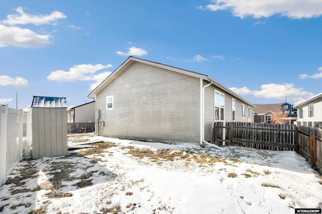 snow covered property featuring a fenced backyard and a residential view