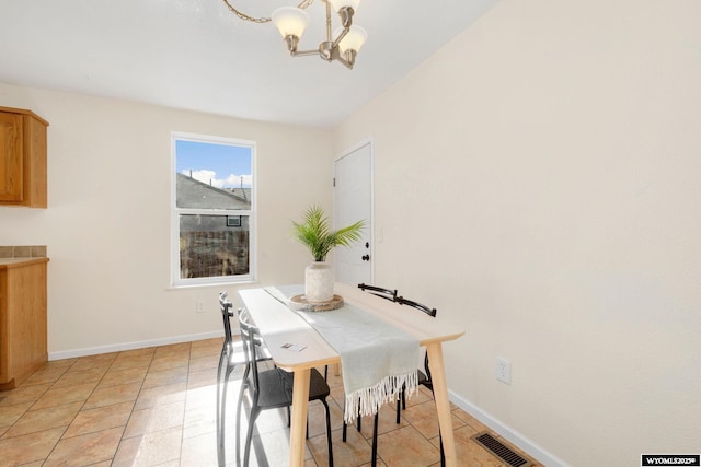 dining room featuring light tile patterned floors, visible vents, baseboards, and an inviting chandelier