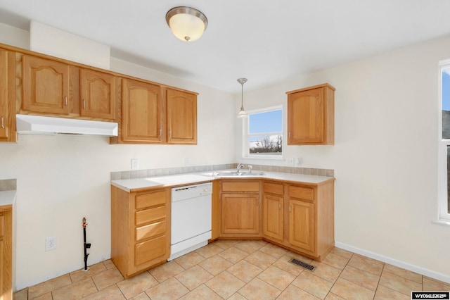 kitchen featuring under cabinet range hood, light countertops, dishwasher, and decorative light fixtures