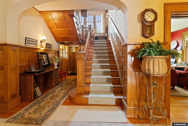 stairway with hardwood / wood-style floors and vaulted ceiling