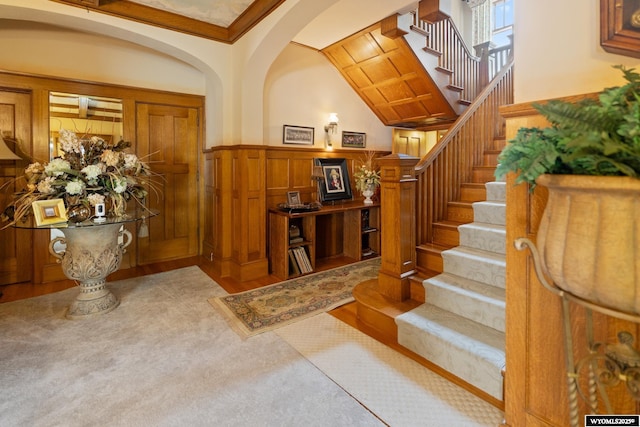 entryway featuring crown molding and wood walls