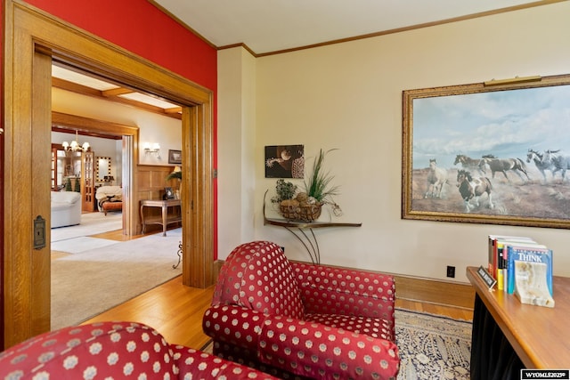 sitting room with light hardwood / wood-style flooring, crown molding, and a notable chandelier