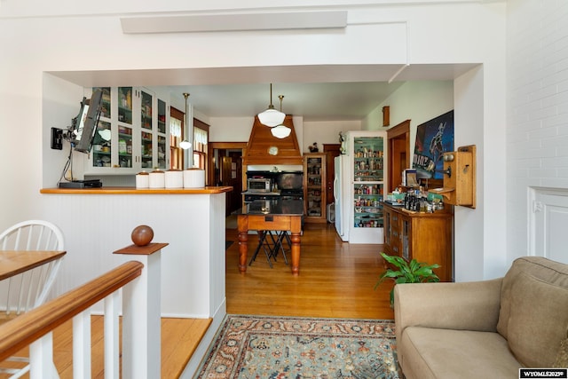 kitchen featuring wood-type flooring, white refrigerator, and decorative light fixtures