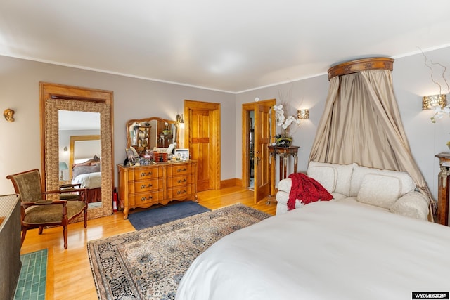 bedroom with light wood-type flooring and ornamental molding