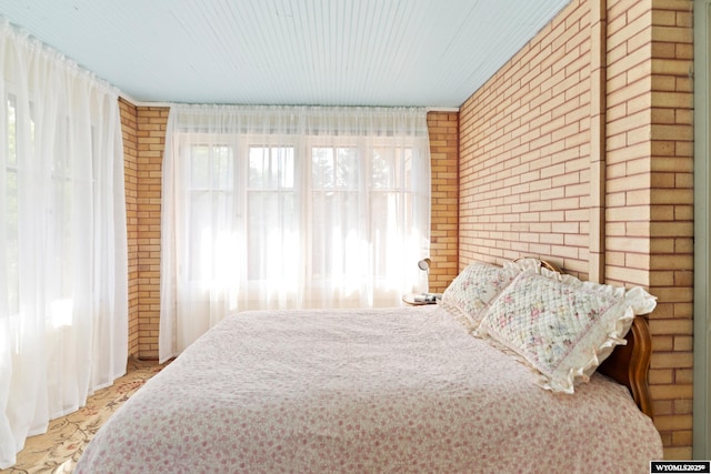 bedroom featuring brick wall