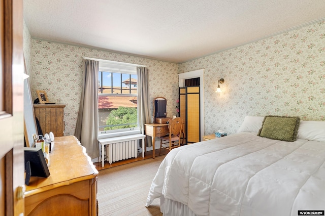 bedroom featuring radiator heating unit, ornamental molding, and a textured ceiling