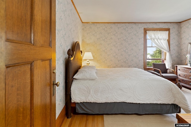 bedroom with hardwood / wood-style floors and crown molding