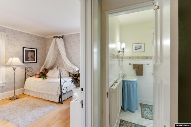 bedroom with crown molding and light hardwood / wood-style flooring