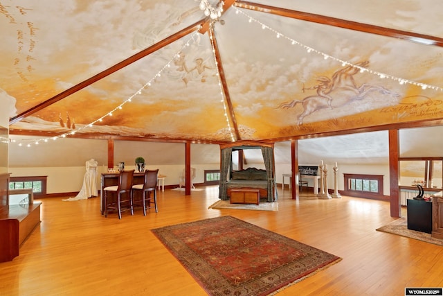 additional living space with wood-type flooring, vaulted ceiling, and a wealth of natural light