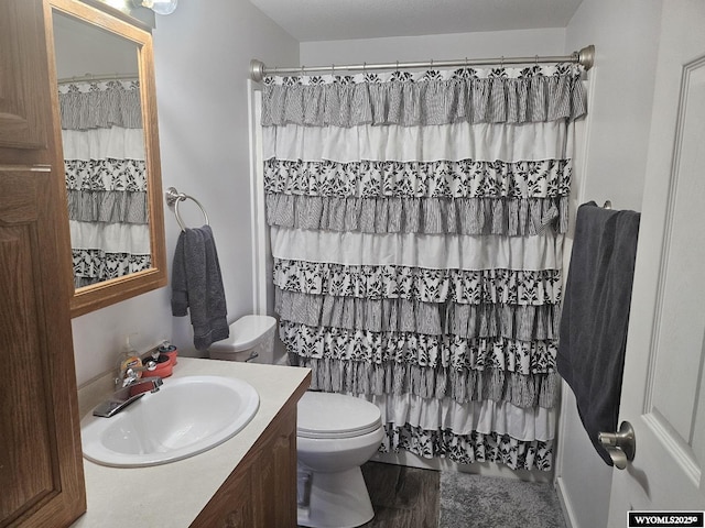 bathroom featuring wood-type flooring, curtained shower, toilet, and vanity