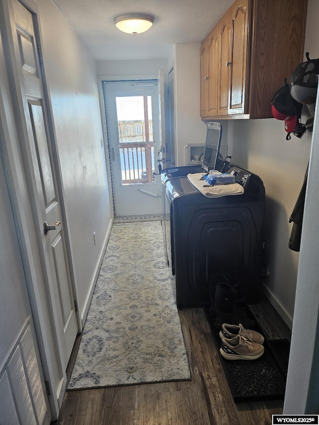 washroom with cabinets, washer and clothes dryer, and dark hardwood / wood-style flooring