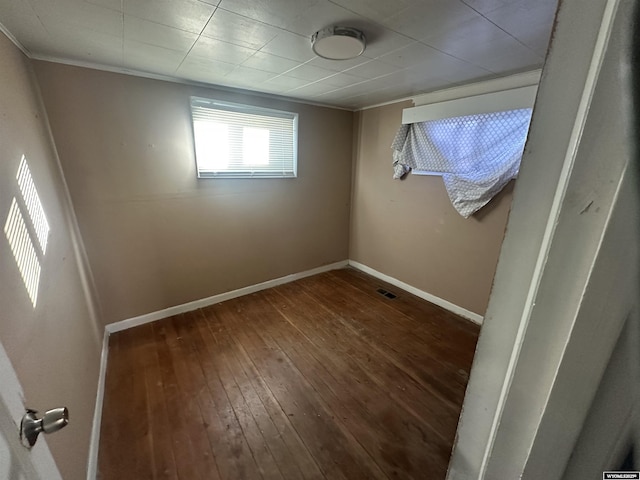 unfurnished room featuring crown molding and dark hardwood / wood-style flooring