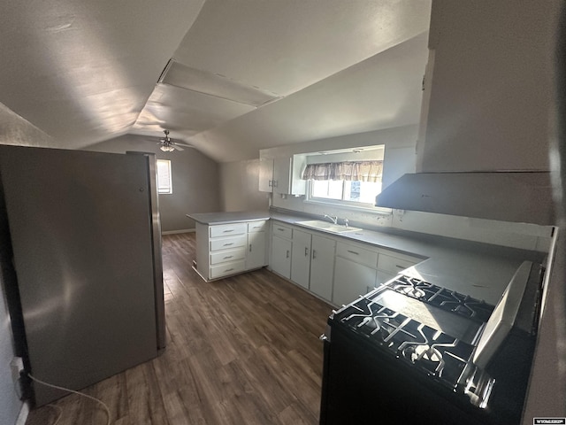 kitchen featuring lofted ceiling, sink, white cabinets, dark hardwood / wood-style flooring, and kitchen peninsula