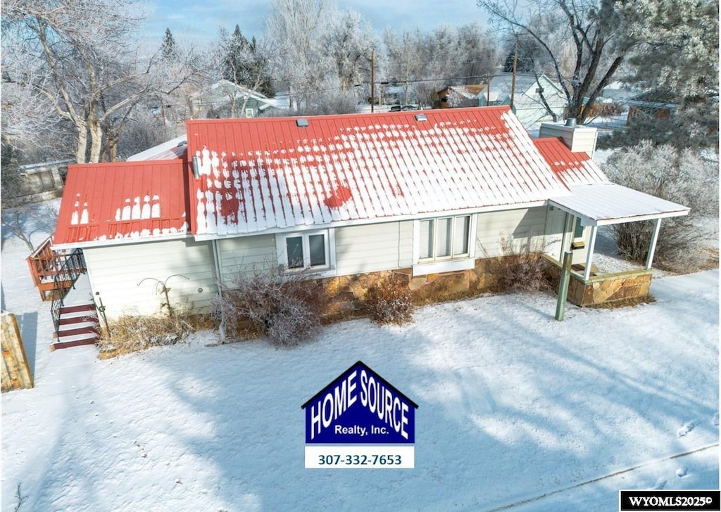 view of snow covered back of property