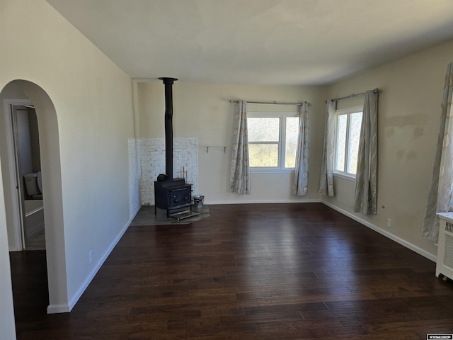 unfurnished living room featuring dark hardwood / wood-style floors and a wood stove