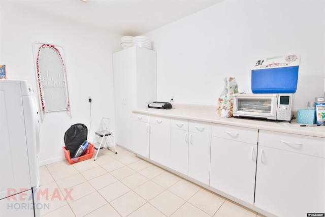 laundry area with washer / dryer and light tile patterned floors