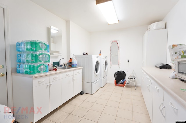 washroom featuring light tile patterned flooring, cabinets, sink, and washer and dryer