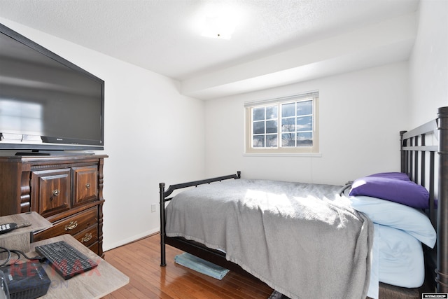 bedroom featuring a textured ceiling and light hardwood / wood-style floors