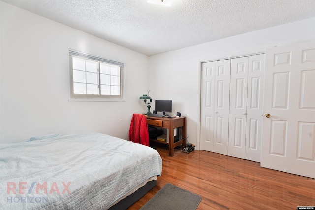 bedroom with hardwood / wood-style flooring, a closet, and a textured ceiling