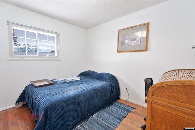 bedroom featuring hardwood / wood-style flooring and a textured ceiling