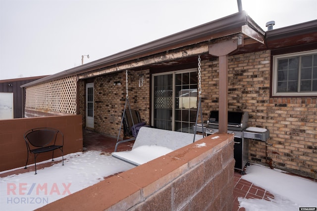 snow covered patio with grilling area