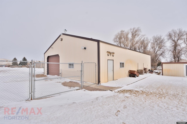 snow covered structure with a garage