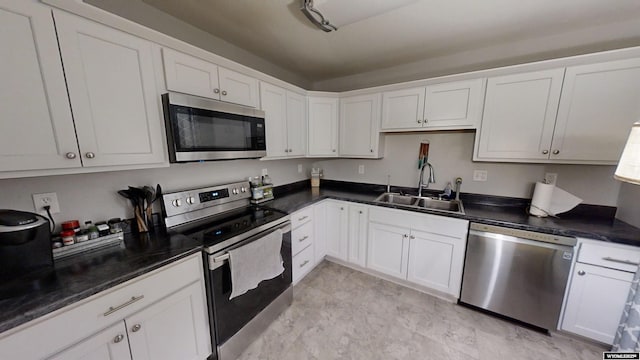 kitchen with stainless steel appliances, white cabinetry, and sink