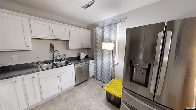 kitchen with appliances with stainless steel finishes, sink, and white cabinets