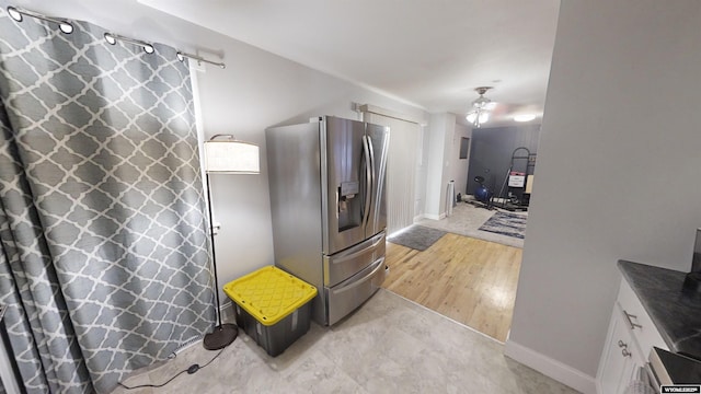 kitchen with a barn door, white cabinets, light hardwood / wood-style floors, and stainless steel fridge with ice dispenser