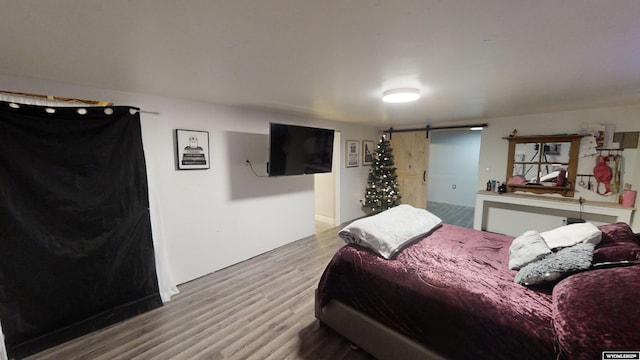 bedroom featuring hardwood / wood-style flooring and a barn door