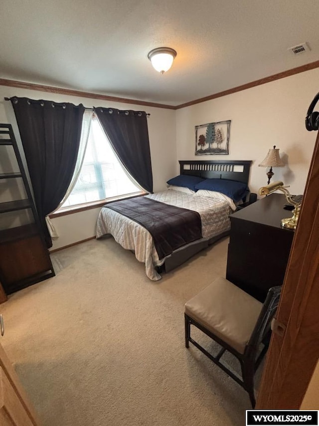 carpeted bedroom featuring ornamental molding and visible vents