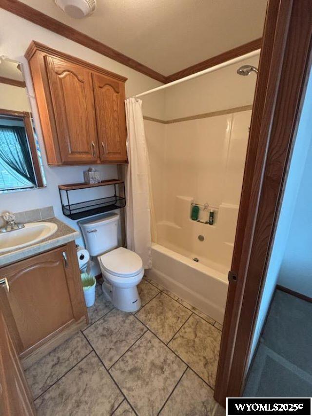 bathroom featuring toilet, ornamental molding, tile patterned floors, shower / bath combination with curtain, and vanity