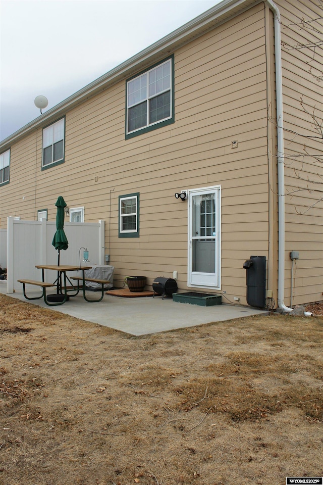 back of property featuring a patio area and fence