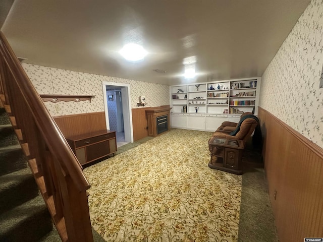 interior space with dark colored carpet, wooden walls, and a fireplace