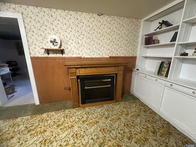 unfurnished living room with carpet floors and wooden walls