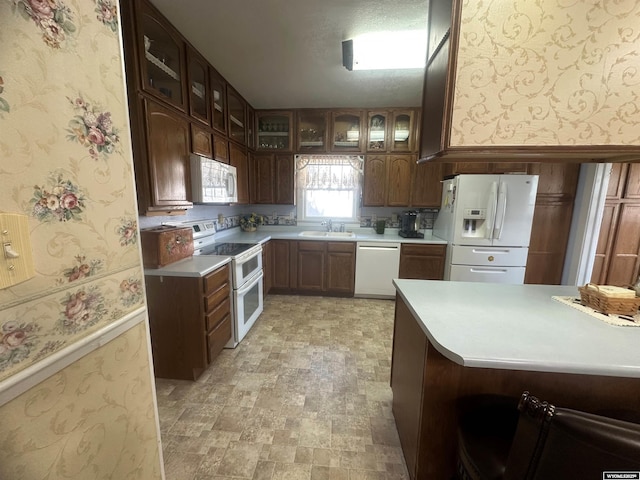 kitchen featuring sink, white appliances, and kitchen peninsula