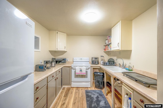 kitchen featuring sink, white cabinetry, white appliances, and light hardwood / wood-style flooring