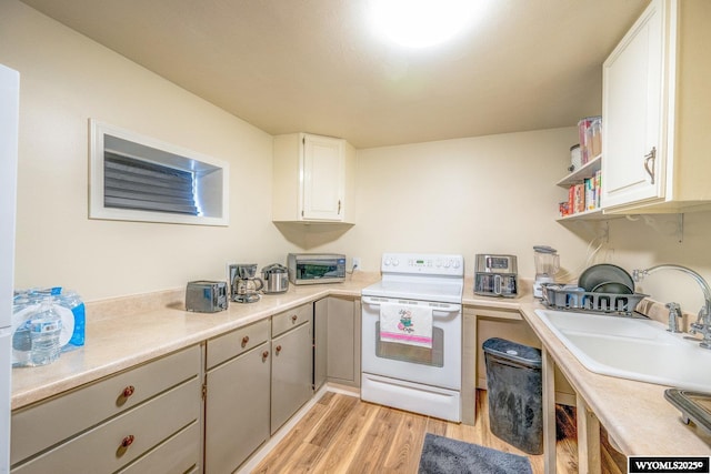 kitchen with sink, white cabinetry, light hardwood / wood-style flooring, and white electric range