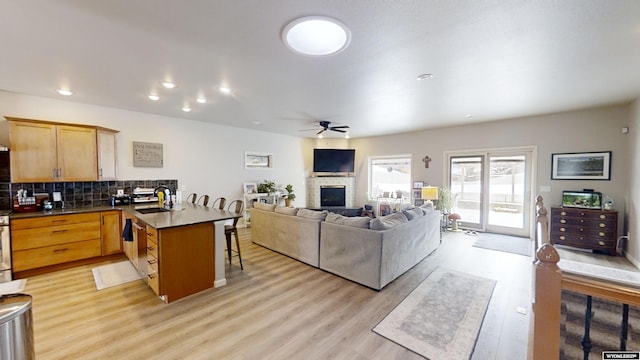 living room with ceiling fan, sink, and light hardwood / wood-style flooring