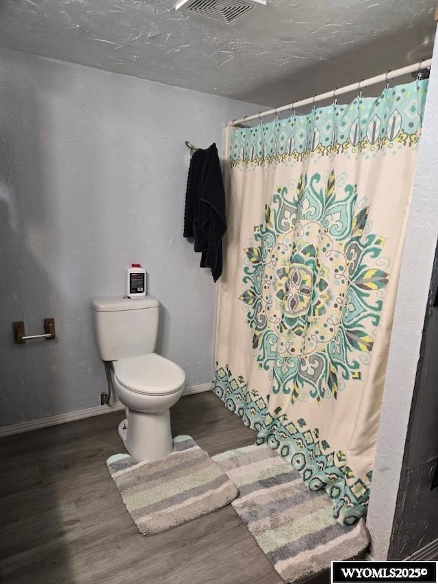 bathroom featuring wood finished floors, visible vents, and baseboards