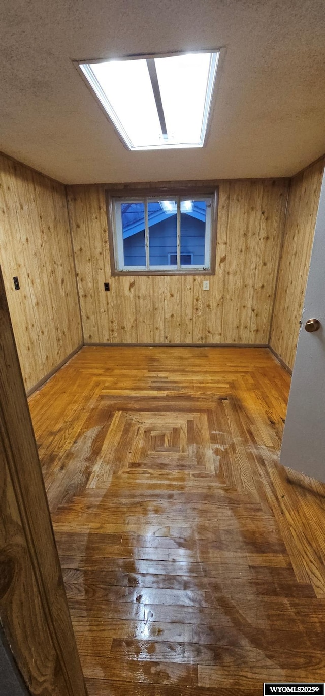 bonus room with wooden walls and a textured ceiling