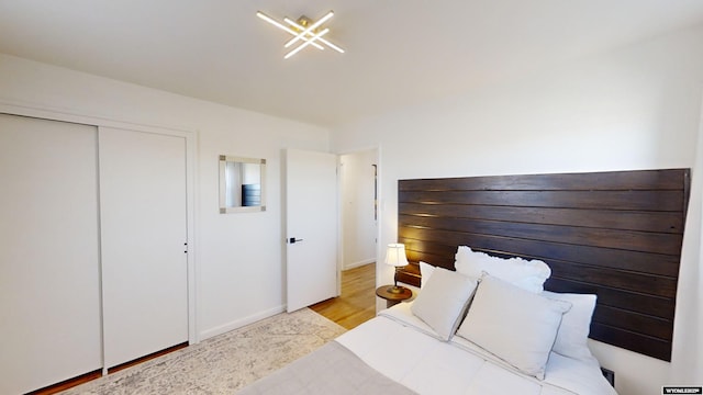 bedroom with light hardwood / wood-style flooring and a closet