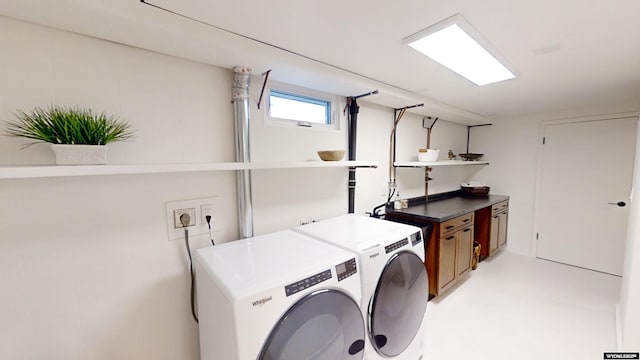 clothes washing area featuring cabinets and washing machine and clothes dryer