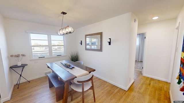 dining space featuring a notable chandelier and light hardwood / wood-style flooring