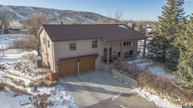 view of front facade featuring cooling unit, a garage, and a mountain view