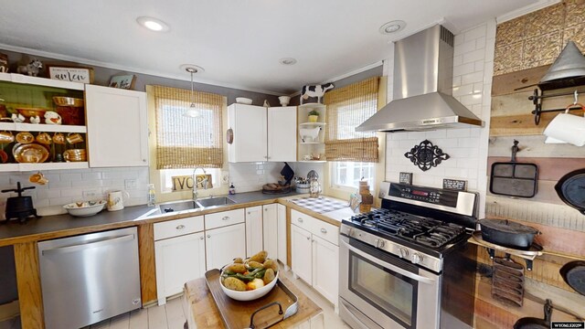 kitchen featuring white cabinetry, island range hood, stainless steel appliances, and decorative light fixtures