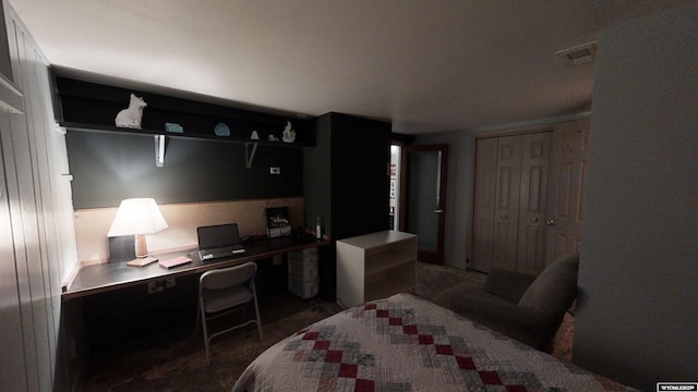 bedroom featuring built in desk, dark carpet, and a closet