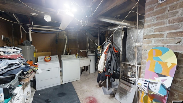 basement featuring water heater, washer and dryer, and sink