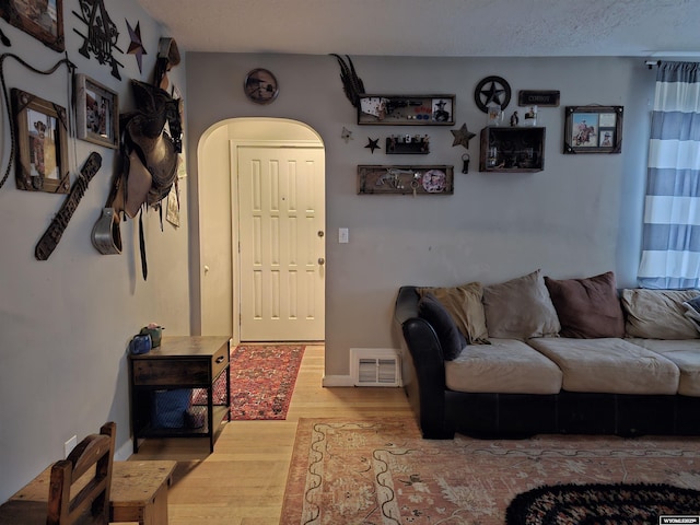 living room with hardwood / wood-style floors and a textured ceiling