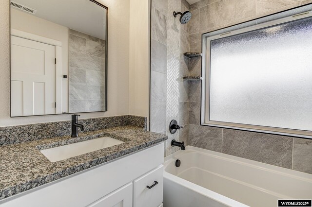 bathroom featuring vanity and tiled shower / bath combo